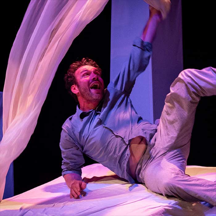 Un jeune homme jouant avec ses draps