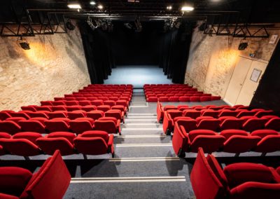 Salle de spectacle depuis le haut des gradins, plateau avec petits pendrillons