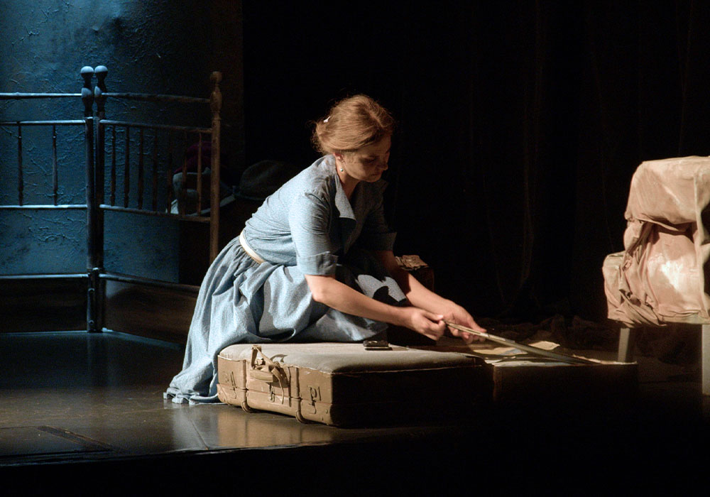 Charlotte © Eric Be_lhassen (2) Spectacle Charlotte, une jeune femme en robe bleue fait sa valide au sol